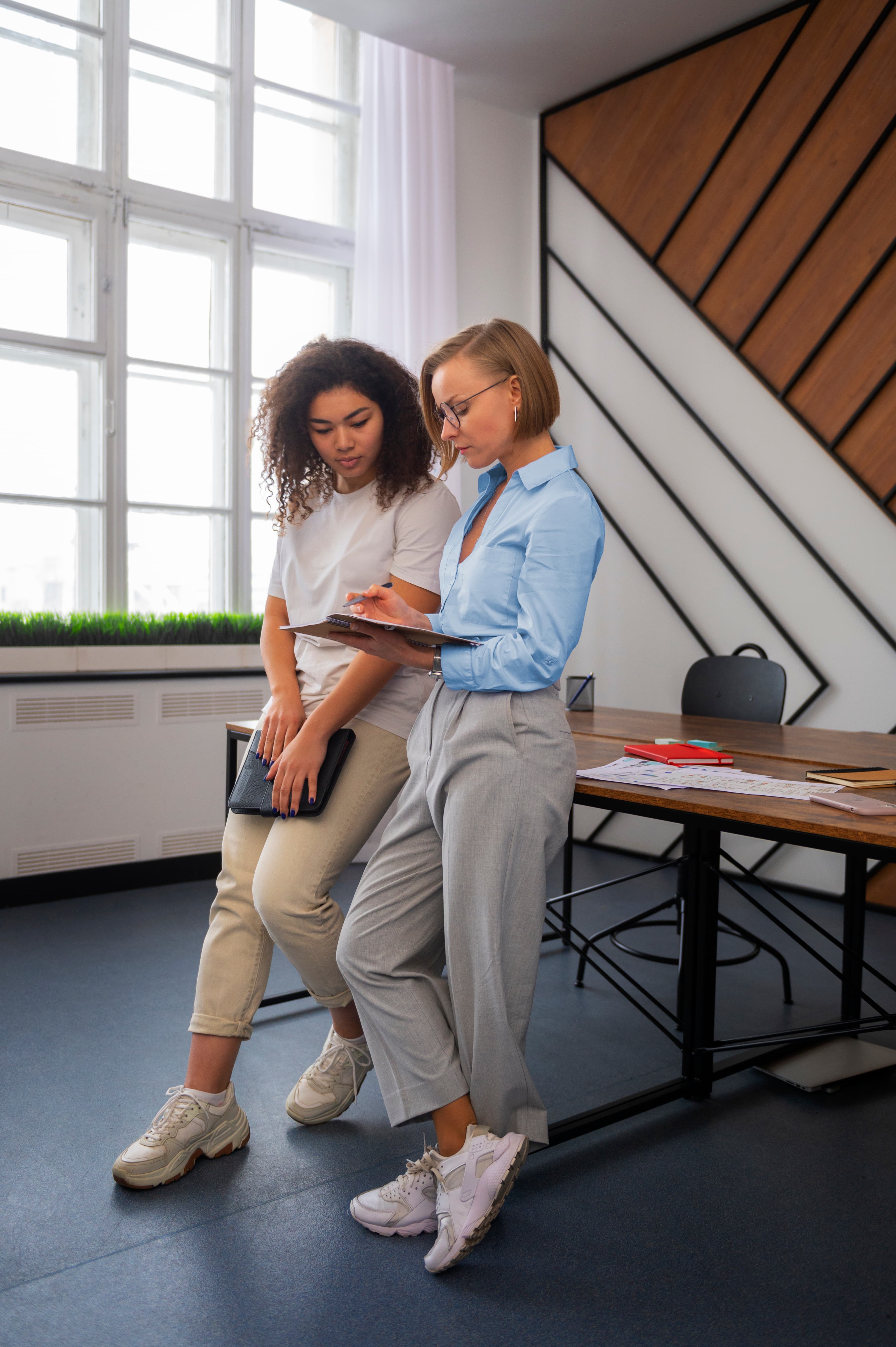 Two professionals collaborating on a tablet in a modern office, discussing app development services and AI technology solutions for innovative digital projects.
